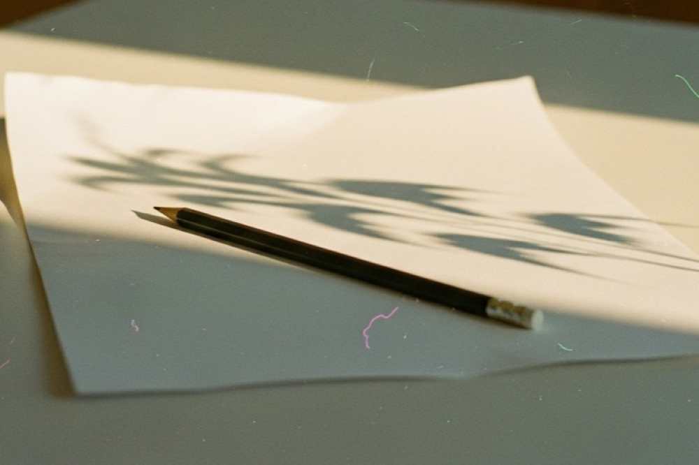 Folio en blanco con un lápiz y luz natural representando el inicio de una propuesta creativa.